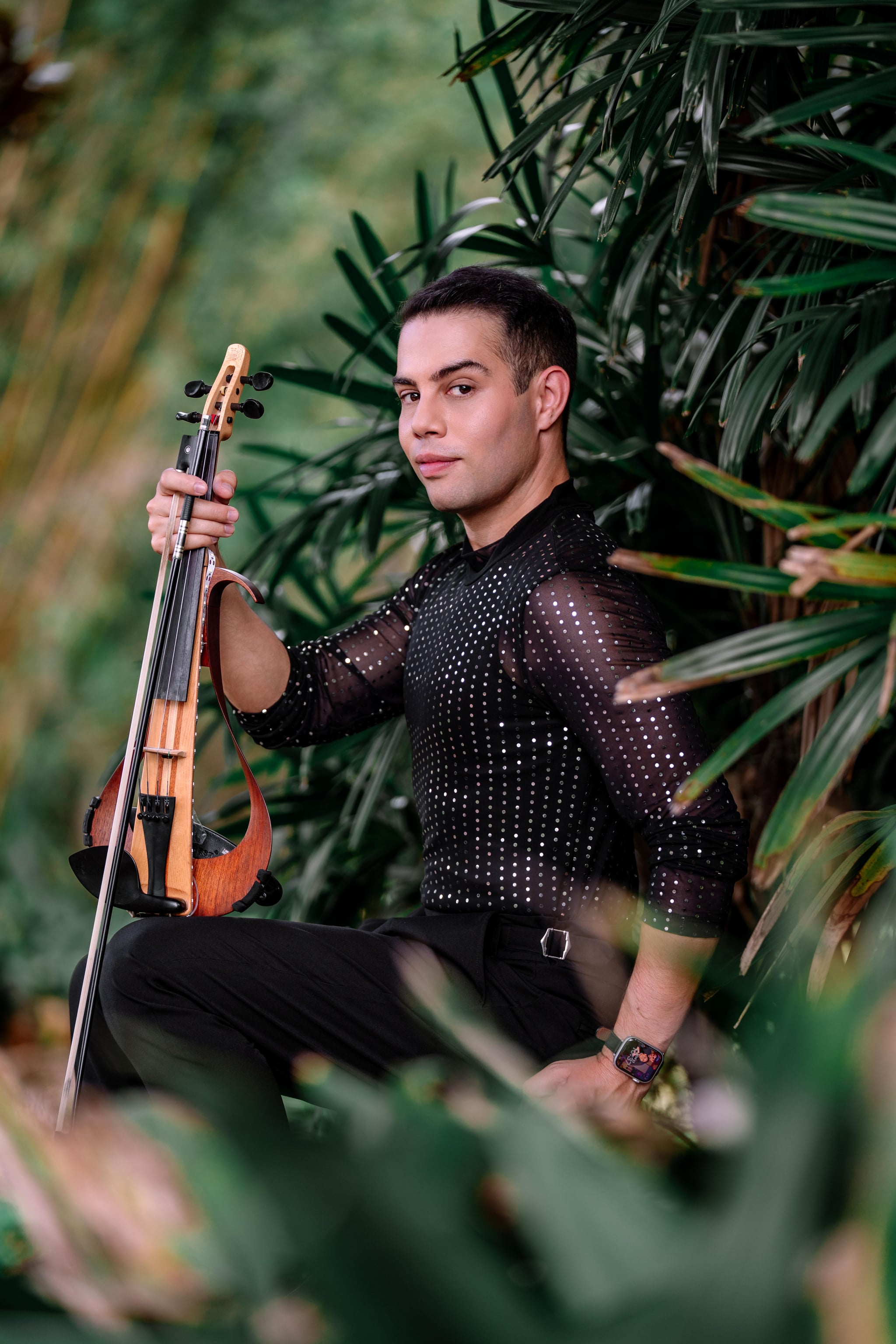 Portrait of violinist David Chirinos holding his electric violin